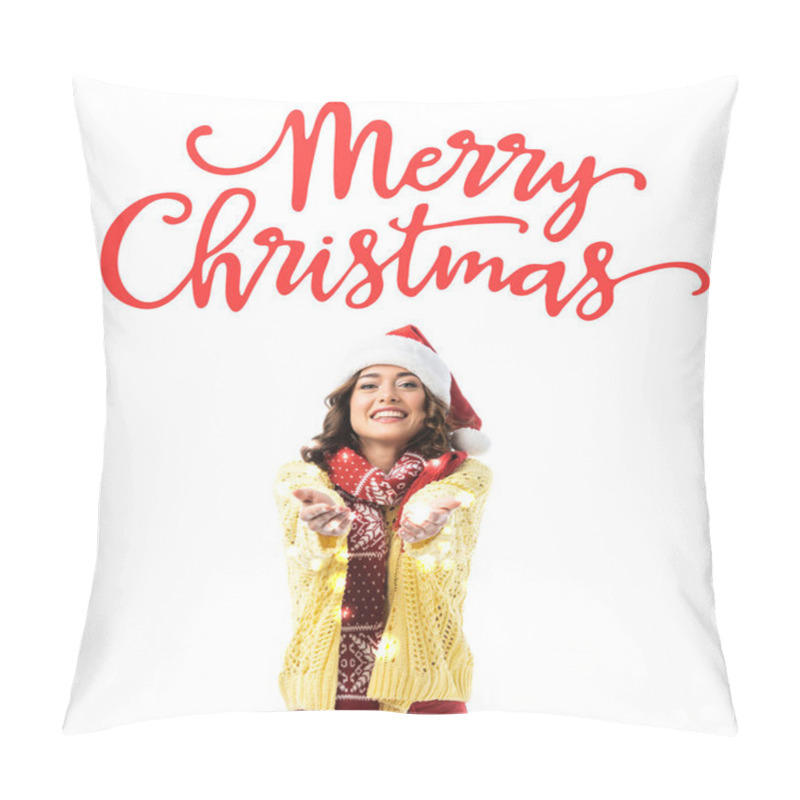 Personality  Joyful Young Woman In Santa Hat And Scarf Standing With Outstretched Hands Near Merry Christmas Lettering On White Pillow Covers