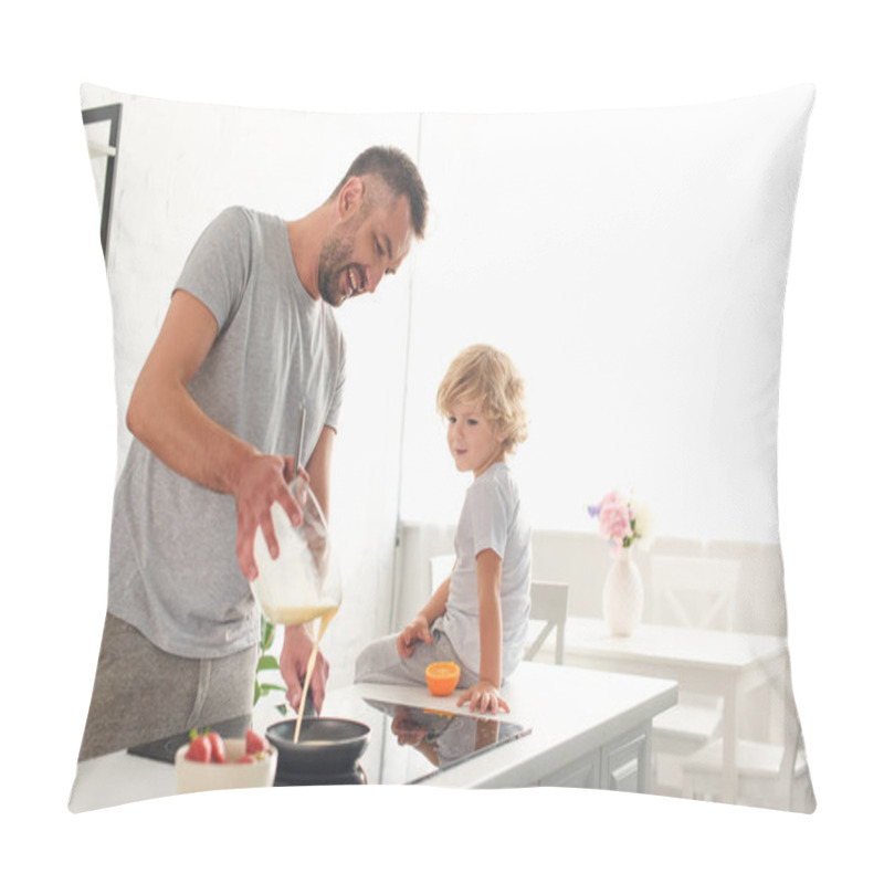 Personality  Smiling Man Pouring Dough Into Frying Pan While His Son Sitting Near On Tabletop At Kitchen Pillow Covers