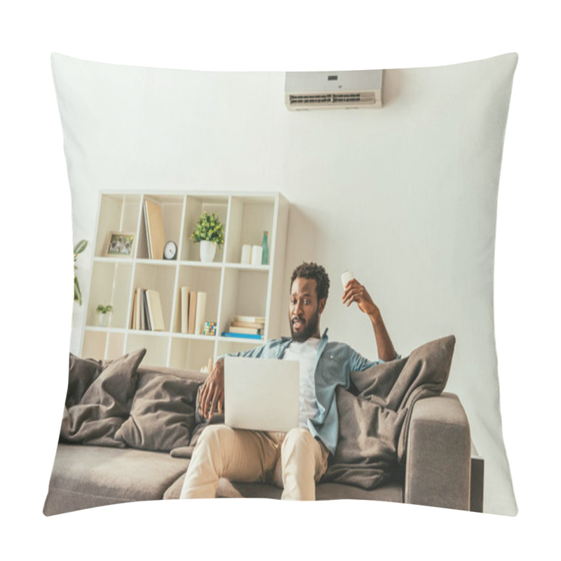 Personality  Handsome African Man Using Laptop While Sitting On Sofa Under Air Conditioner And Holding Remote Controller Pillow Covers