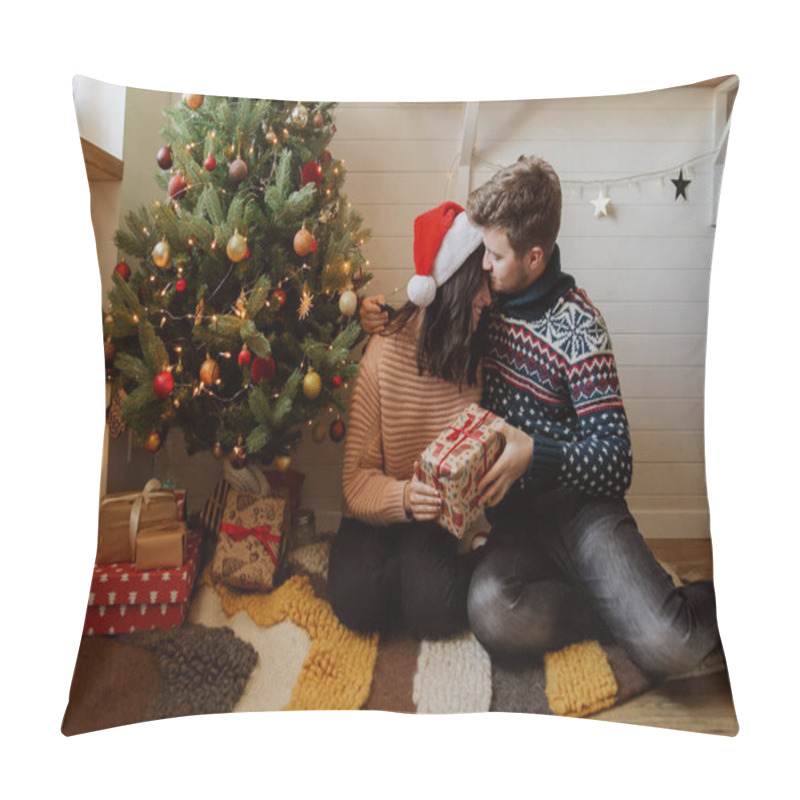 Personality  Stylish Happy Couple Exchanging Christmas Gifts Under Christmas Tree With Lights. Young Family Hugging And Holding Present, Happy Moment In Festive Modern Room. Happy Holidays Pillow Covers