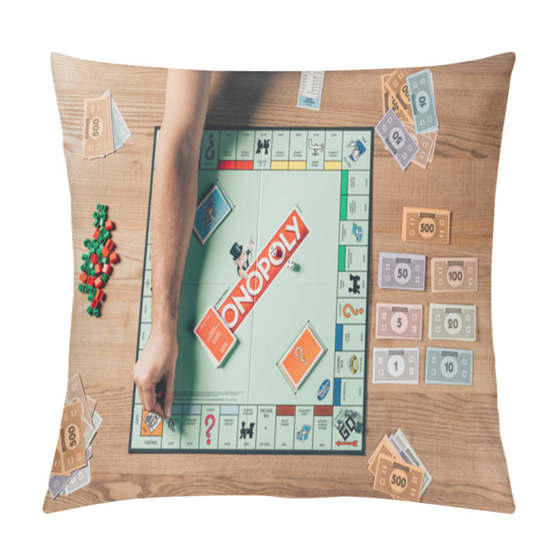 Personality  KYIV, UKRAINE - NOVEMBER 15, 2019: Cropped View Of Man Playing Monopoly Game On Wooden Table Pillow Covers