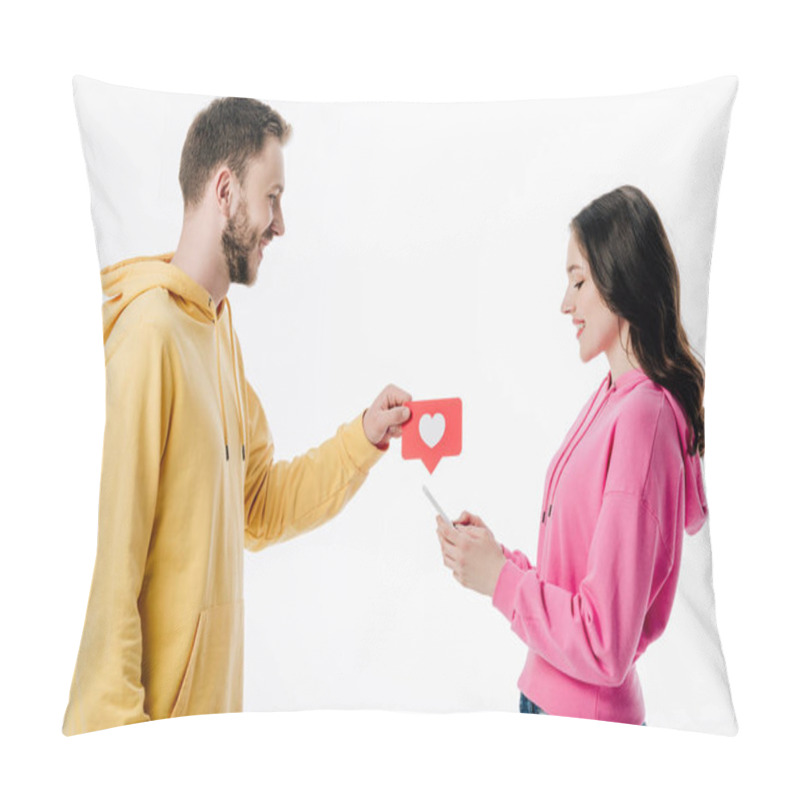 Personality  Side View Of Smiling Young Man Giving Red Paper Cut Card With Heart Symbol To Girlfriend Using Smartphone Isolated On White Pillow Covers