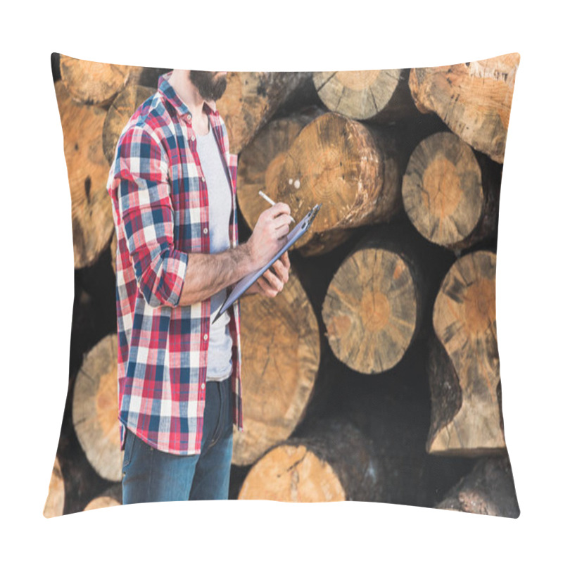 Personality  Cropped Shot Of Bearded Lumberjack In Checkered Shirt Writing In Clipboard On Logs Background  Pillow Covers