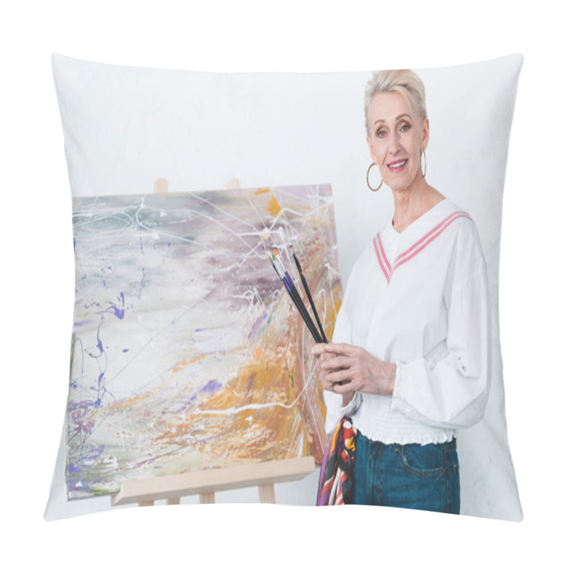 Personality  Senior Elegant Female Artist Holding Paintbrushes And Standing Near Painting On Easel In Workshop Pillow Covers