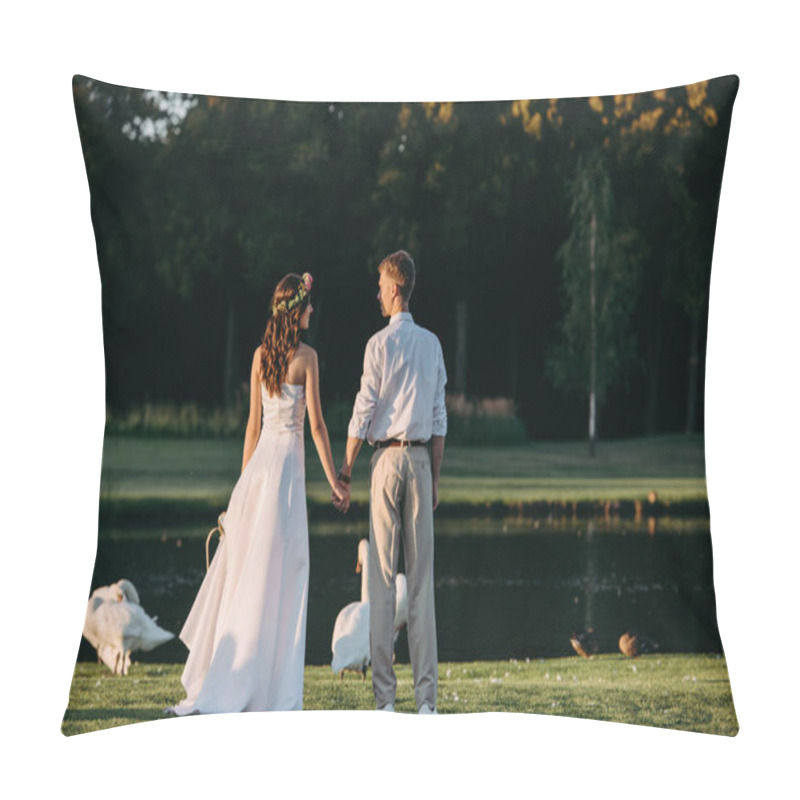 Personality  Back View Of Young Wedding Couple Holding Hands And Standing On Green Grass Near Lake With Beautiful Swans  Pillow Covers