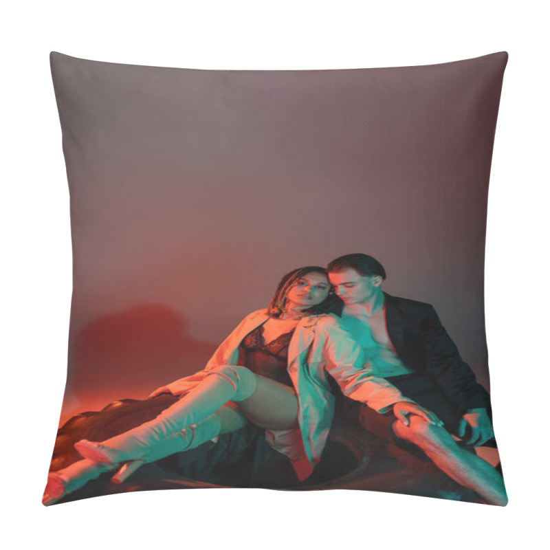 Personality  Trendy Interracial Couple Sitting On Huge Tire, Shirtless Man In Black Blazer And African American Woman In Lace Bodysuit, Beige Trench Coat And Over Knee Boots On Grey Background With Red Lighting Pillow Covers