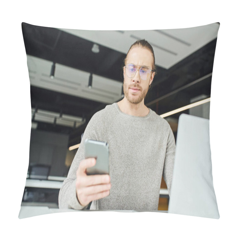 Personality  Entrepreneur In Eyeglasses And Casual Clothes, With Serious Face Expression, Looking At Mobile Phone While Working On Startup Project Near Laptop On Blurred Foreground In Modern Office Space Pillow Covers