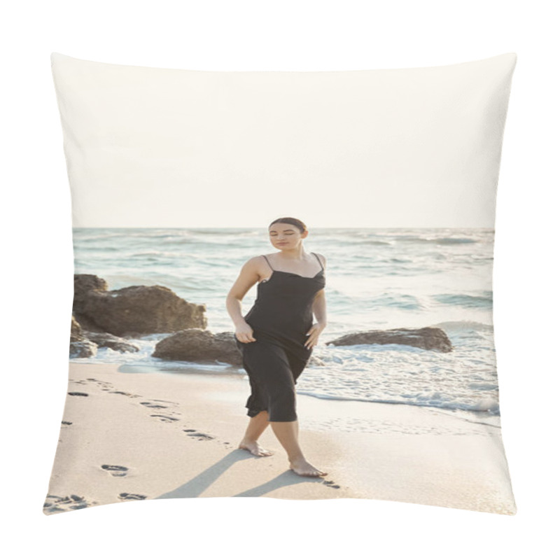 Personality  A Young Woman In A Black Sundress Walks Barefoot On A Sandy Beach, Leaving Footprints Behind. The Ocean Waves Lap At The Shore Behind Her. Pillow Covers