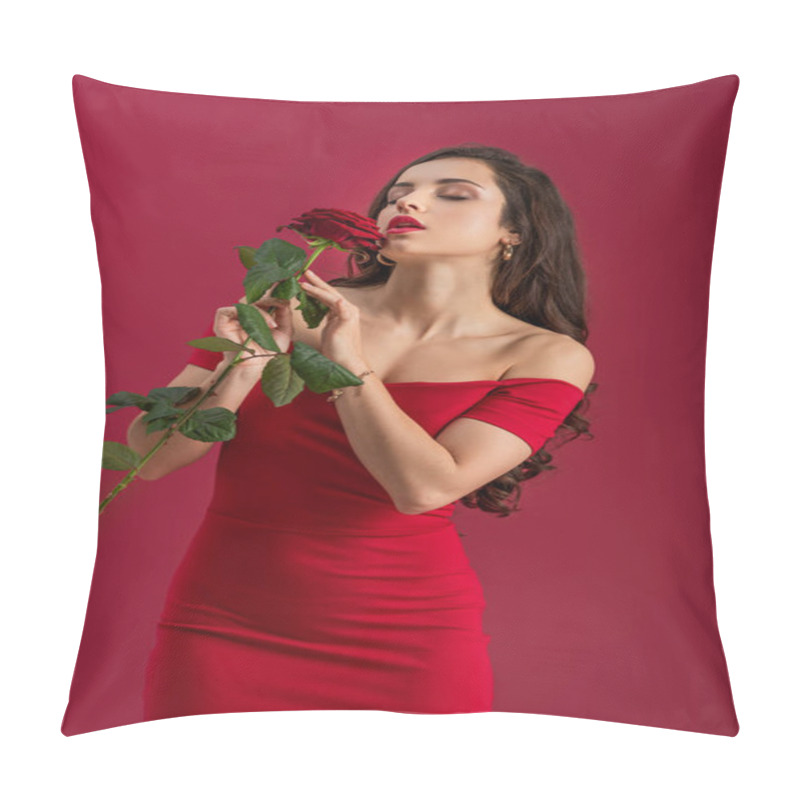 Personality  sexy, elegant girl enjoying flavor of red rose with closed eyes isolated on red pillow covers