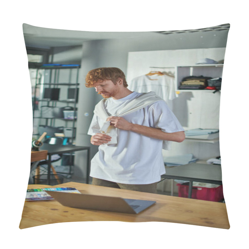 Personality  Young Redhead Craftsman In Casual Clothes Looking At Cloth Samples Near Laptop On Working Table In Blurred Print Studio At Background, Self-made Success Concept  Pillow Covers