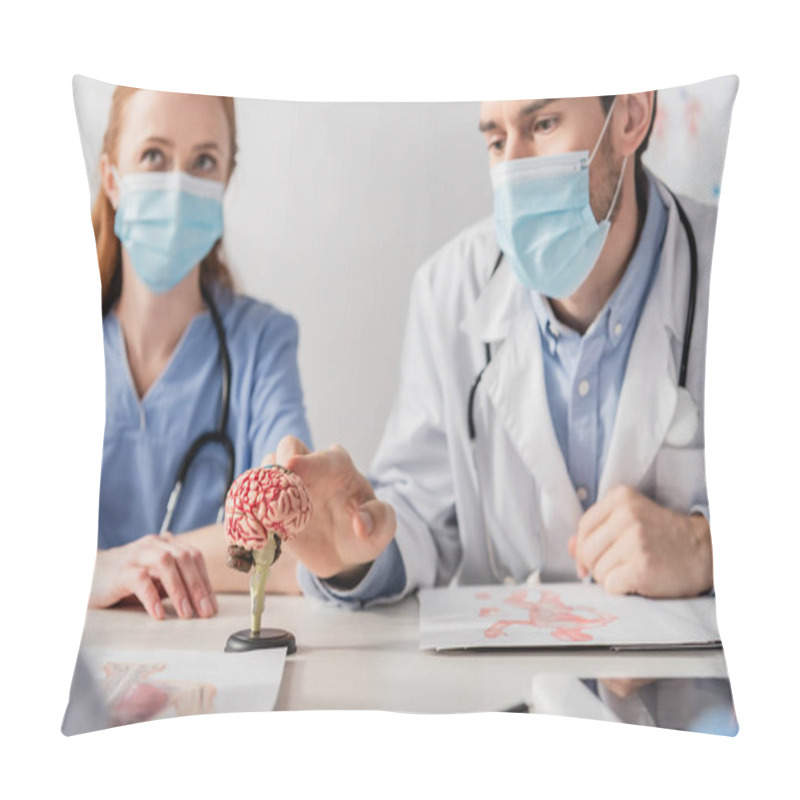 Personality  Doctor In Medical Mask Touching Brain Anatomical Model While Sitting At Workplace Near Colleagues On Blurred Foreground Pillow Covers