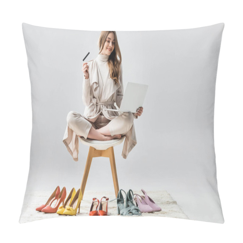 Personality  Cheerful Girl Sitting On Chair In Lotus Pose, Holding Laptop And Credit Card Near Collection Of Shoes On Grey Background Pillow Covers