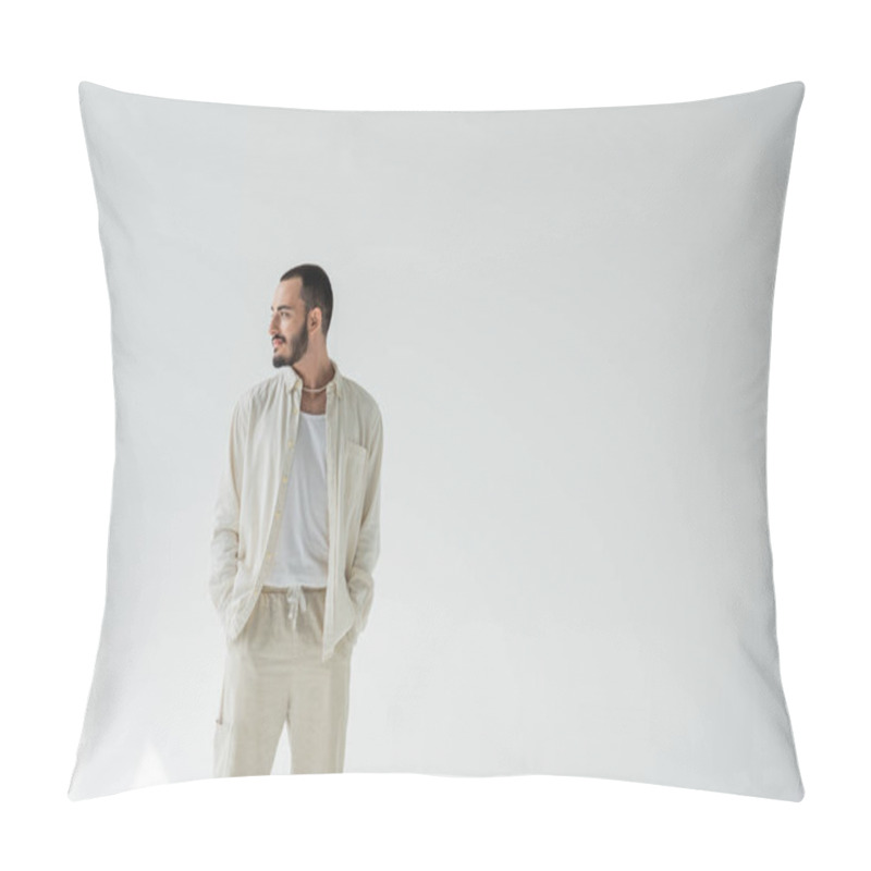 Personality  Smiling Homosexual Man In Beige Clothes And Pearl Necklace Holding Hands In Pockets Of Pants And Looking Away While Standing On Grey Background With Sunlight  Pillow Covers