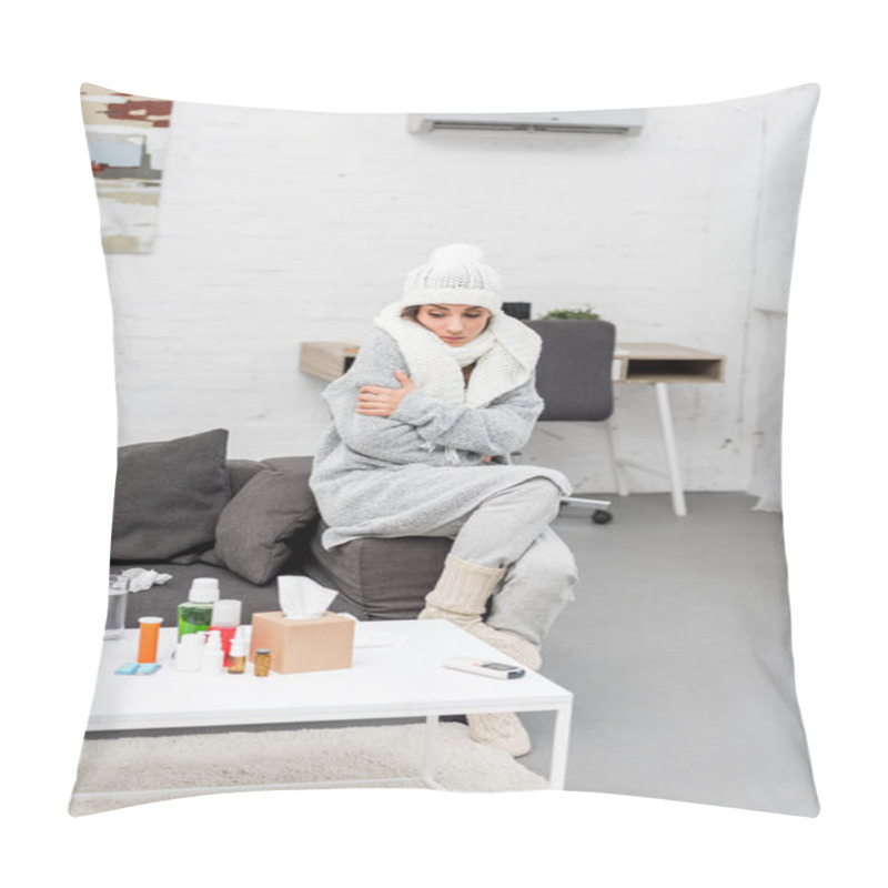 Personality  Sick Young Woman In Warm Clothes Sitting On Couch And Looking At Medicines On Table Pillow Covers