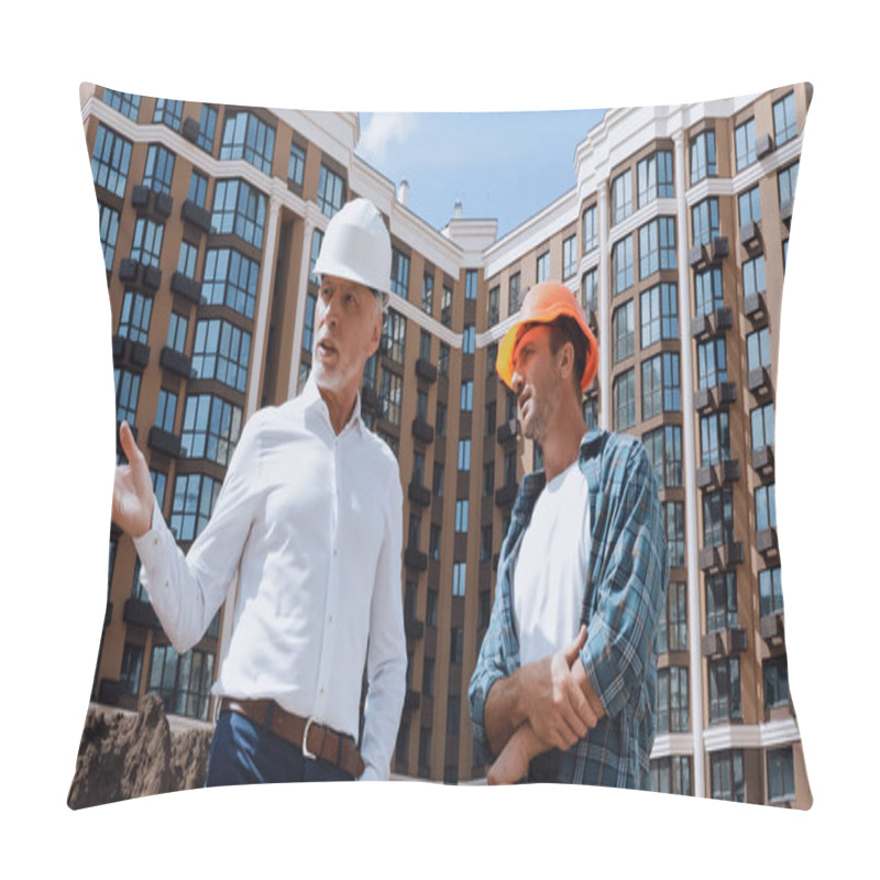 Personality  Low Angle View Of Engineer Gesturing Near Builder While Talking Near New Building Pillow Covers