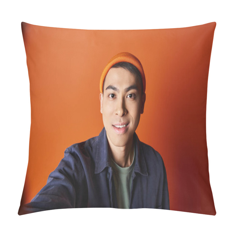 Personality  Handsome Asian Man Dressed In Stylish Attire Taking A Selfie While Wearing An Orange Hat In A Vibrant Studio Setting. Pillow Covers