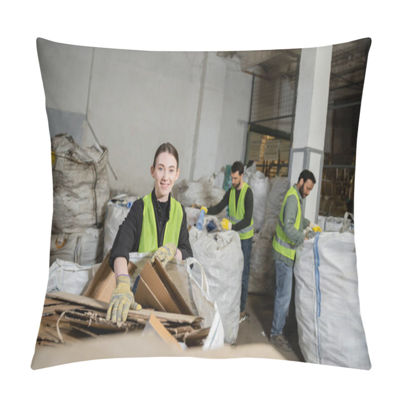 Personality  Worker In Gloves And High Visibility Vest Looking At Camera While Putting Cardboard In Sack And Working Near Multiethnic Colleagues In Waste Disposal Station, Garbage Sorting And Recycling Concept Pillow Covers