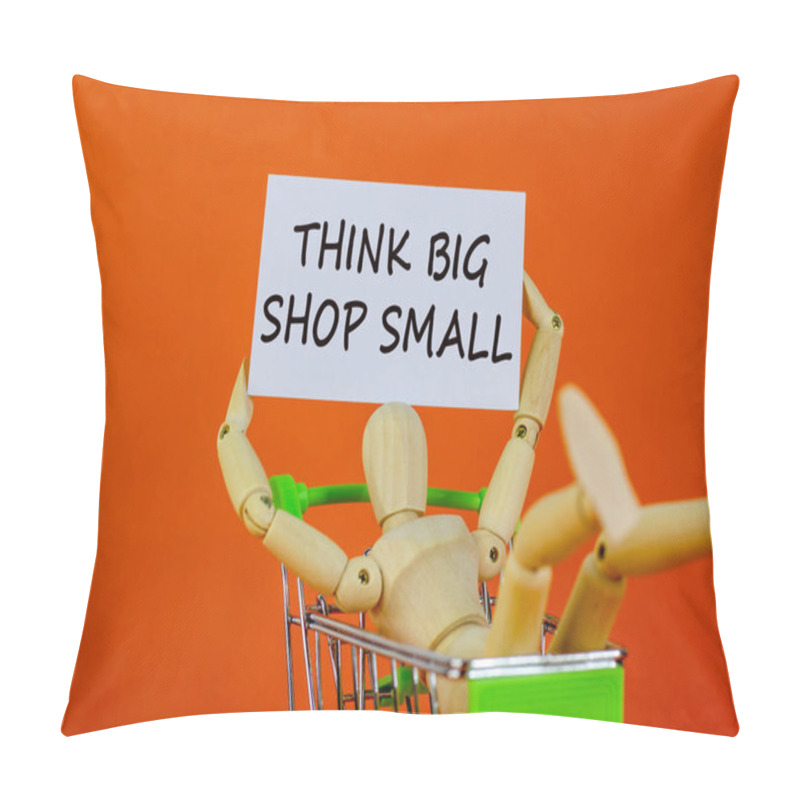 Personality  Think Big Shop Small Symbol. White Sheet Of Paper. Words 'Think Big Shop Small'. Wooden Model Of A Human In A Shopping Cart. Beautiful Orange Background. Business And Sale Concept, Copy Space. Pillow Covers