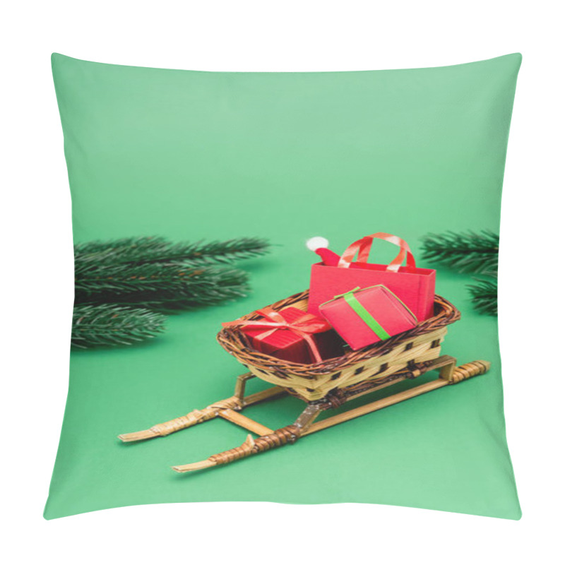 Personality  Gift Boxes And Shopping Bag With Santa Hat In Wicker Basket On Decorative Sleigh Near Fir Branches On Green Pillow Covers