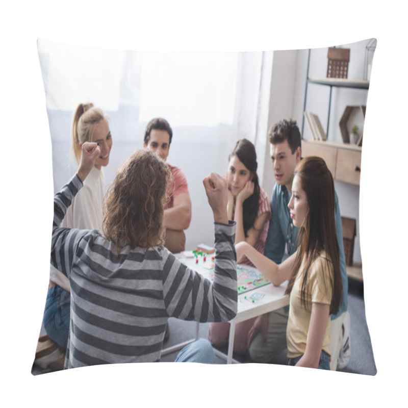 Personality  KYIV, UKRAINE - JANUARY 27, 2020: Back View Of Man Showing Winner Gesture Near Displeased Friends While Playing Monopoly Game Pillow Covers