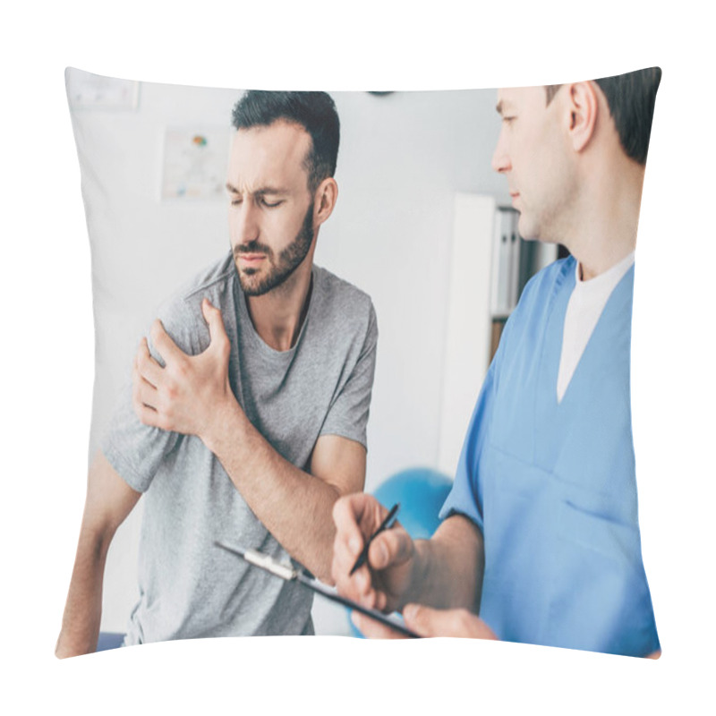 Personality  Selective Focus Of Patient Touching His Shoulder And Suffering From Pain And Doctor Writing Prescription In Massage Cabinet At Clinic Pillow Covers