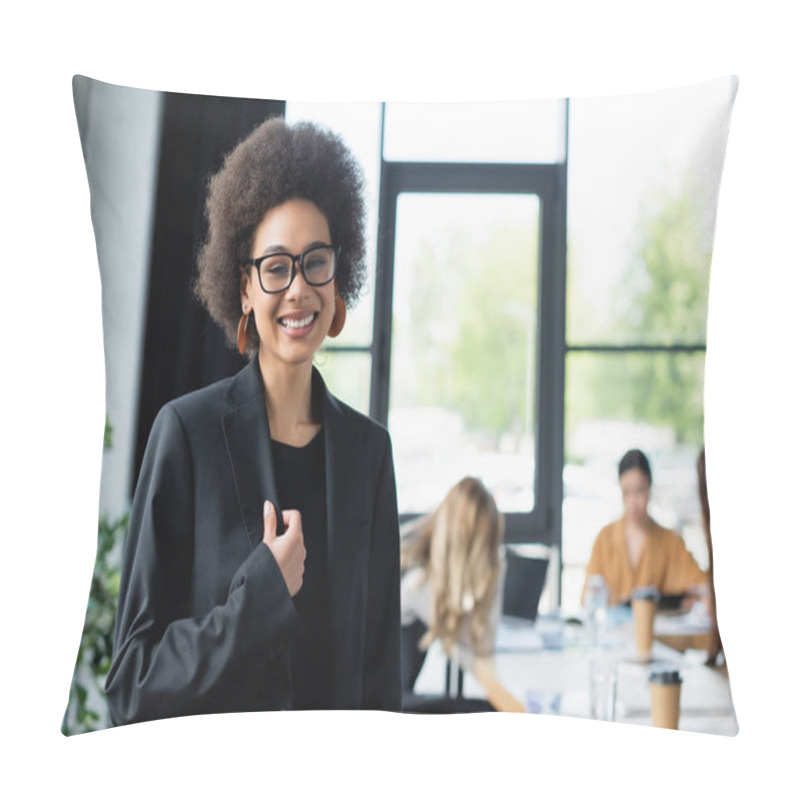 Personality  Cheerful African American Businesswoman Smiling At Camera Near Blurred Managers In Office Pillow Covers