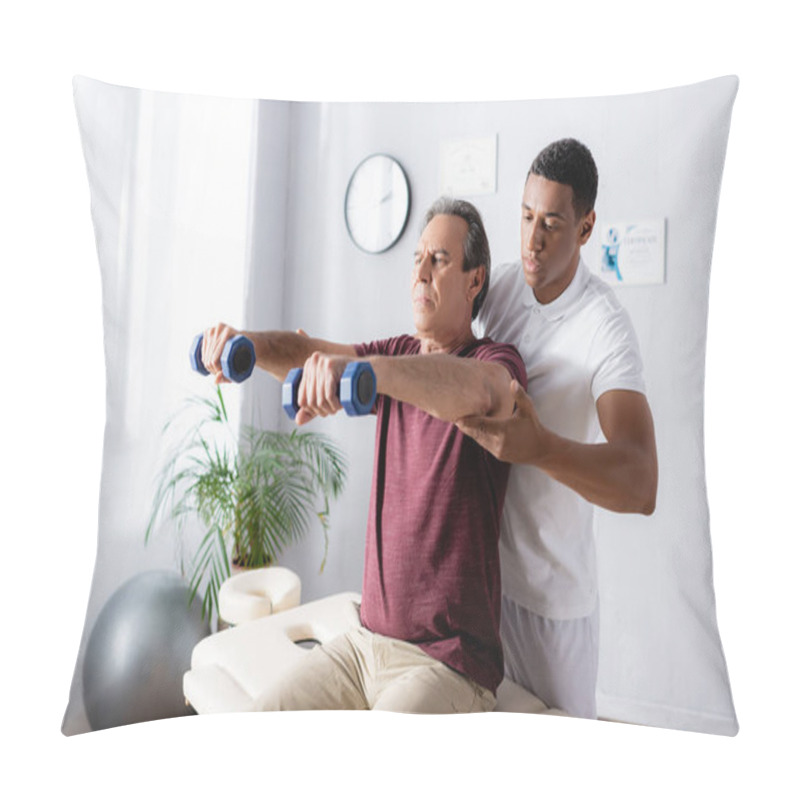 Personality  Middle Aged Man Exercising With Dumbbells On Massage Table Near African American Physiotherapist  Pillow Covers