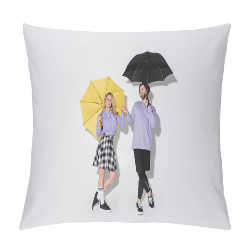 Personality  Full Length Of Pleased Couple In Purple Sweatshirts Holding Hands While Standing Under Umbrellas On Grey Pillow Covers