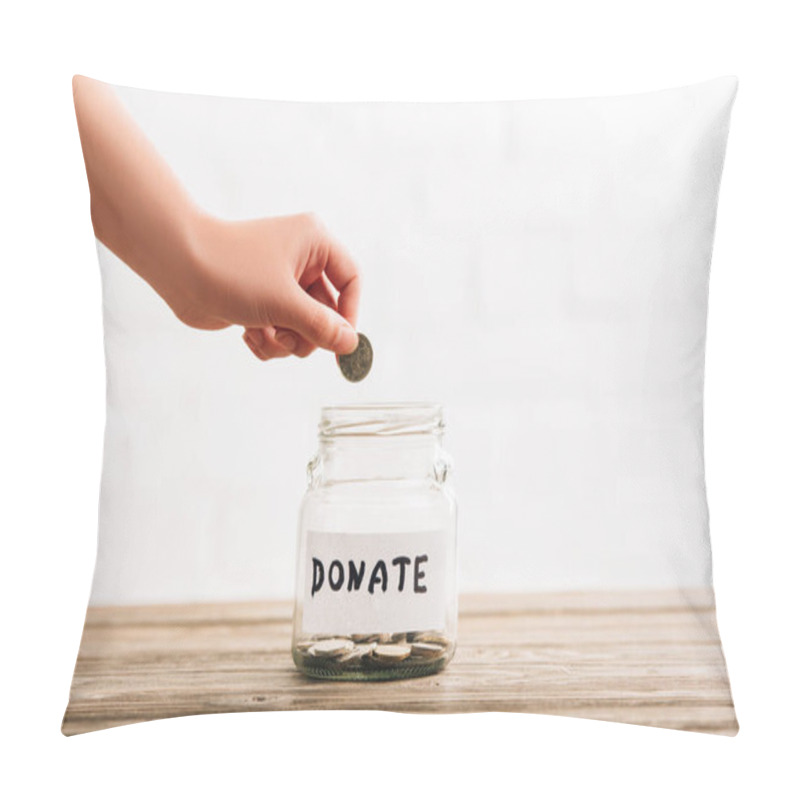 Personality  Cropped View Of Woman Putting Coin In Penny Jar With Donate Lettering On Wooden Surface On White Background Pillow Covers