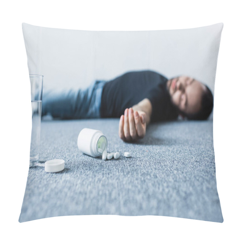 Personality  Selective Focus Of Unconscious Man Lying On Grey Floor Near Glass Of Water And Container With Pills  Pillow Covers