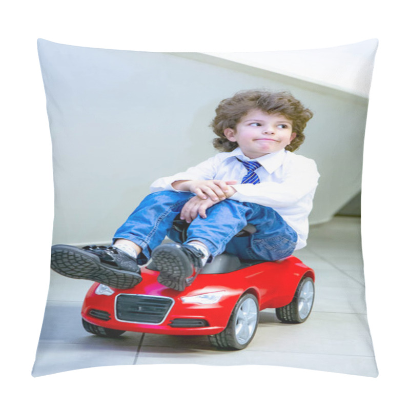 Personality  A Charming Funny Little Boy Wearing A Tie And A Shirt Sits Astride A Small Red Toy Car. Curly-haired Brunette Child Has Fun In The Auto Salon. Business Dealership Concept Pillow Covers