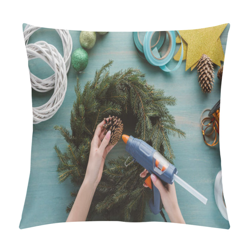 Personality  Cropped Shot Of Woman Decorating Handmade Christmas Wreath With Pine Cone On Blue Wooden Surface Pillow Covers