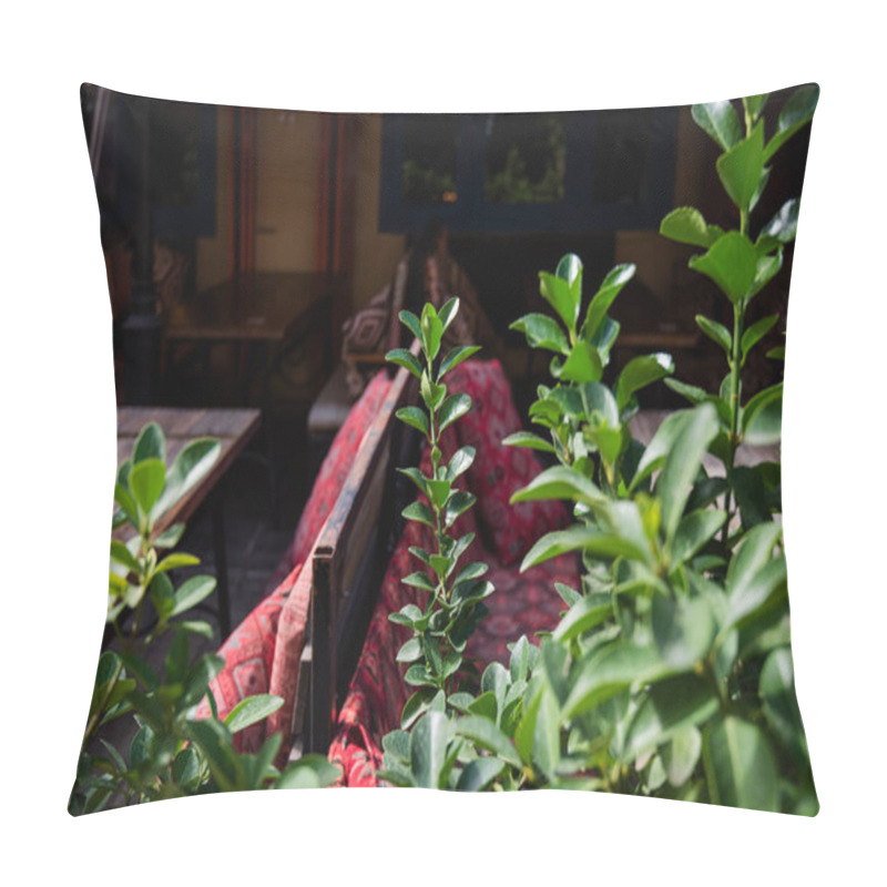 Personality  Cozy Cafe Corner With Wooden Tables And Traditional Red-patterned Textiles, Surrounded By Green Plants, Creating A Warm And Inviting Outdoor Seating Area In A Charming Urban Setting. Pillow Covers