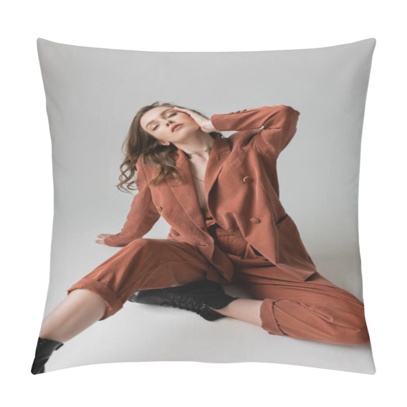 Personality  Full Length Of Chic Young Woman With Brunette And Wavy Hair Sitting With Closed Eyes In Trendy And Oversize Terracotta Suit With Blazer, Pants And Black Boots, On Grey Background, Stylish Model   Pillow Covers