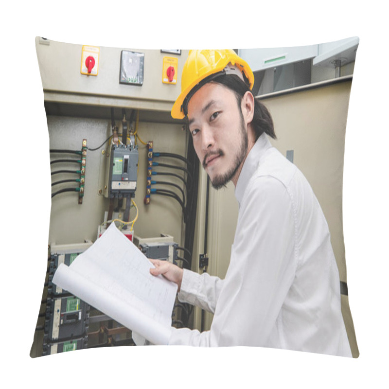 Personality  Close Up Of Young Asian Electric Engineer In Beige Pant And White Shirt, Wear Yellow Helmet, Squat Near Control Panel, Working Instruction In Hand, Follow Up His Routine Daily Checking Pillow Covers