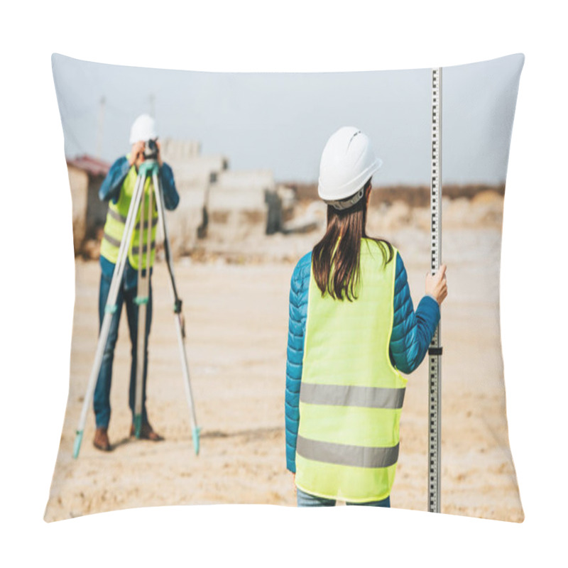 Personality  Selective Focus Of Surveyor Holding Ruler And Colleague With Digital Level On Background Pillow Covers