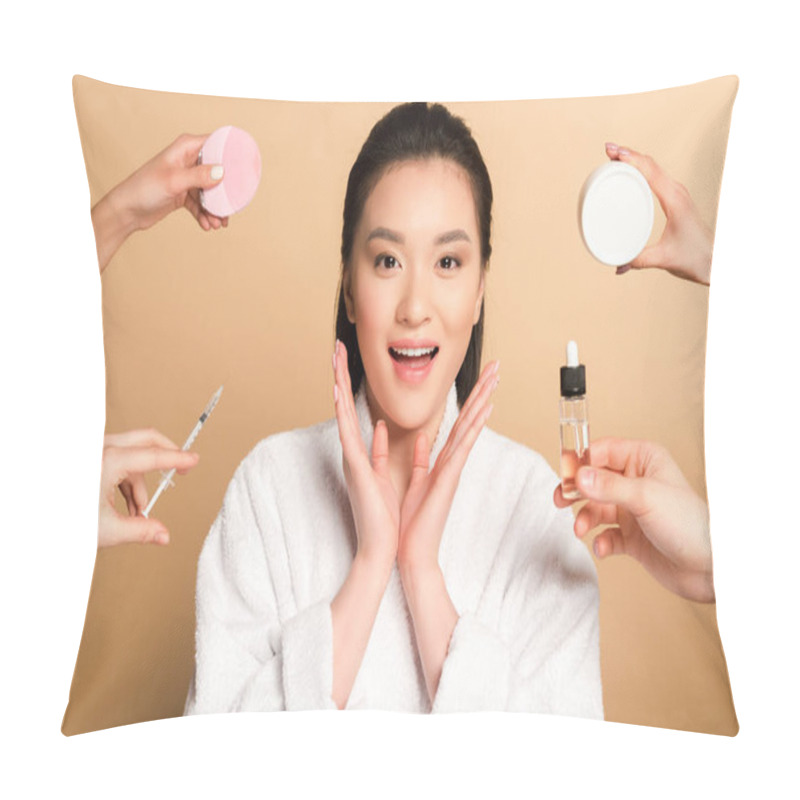 Personality  Surprised Beautiful Asian Woman In Bathrobe Near Hands With Facial Cleansing Brush, Syringe, Cosmetic Cream And Oil On Beige Background Pillow Covers