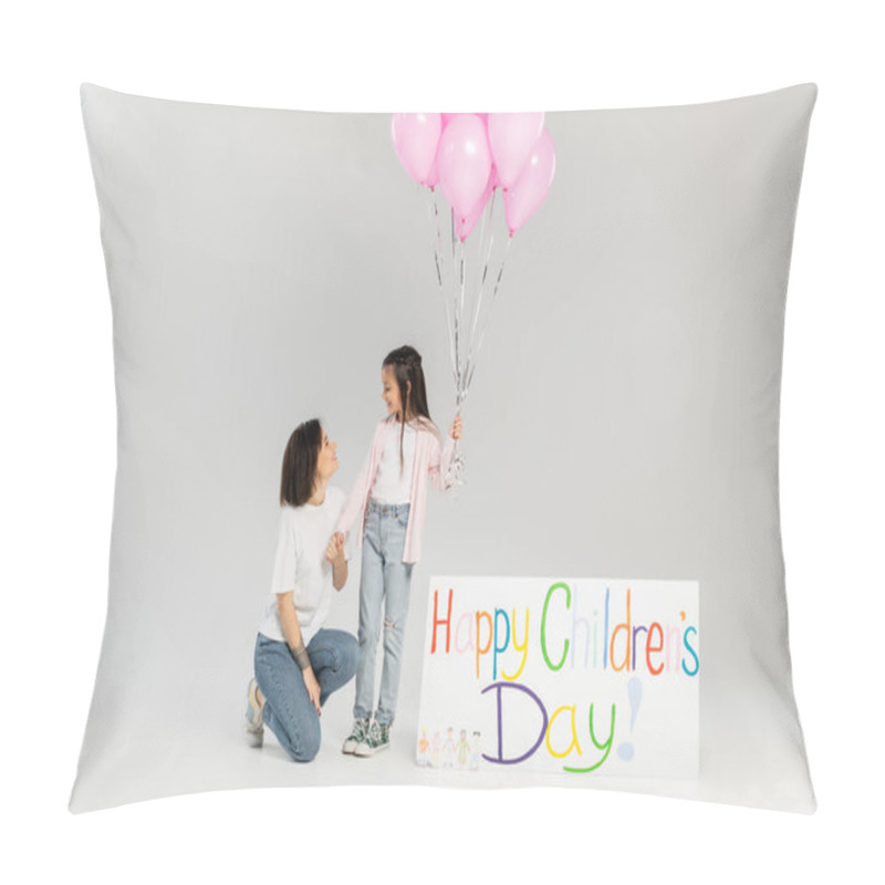 Personality  Side View Of Smiling Mother In Casual Clothes Holding Hand Of Daughter With Pink Balloons Near Placard With Happy Children's Day Lettering During Celebration In June On Grey Background Pillow Covers