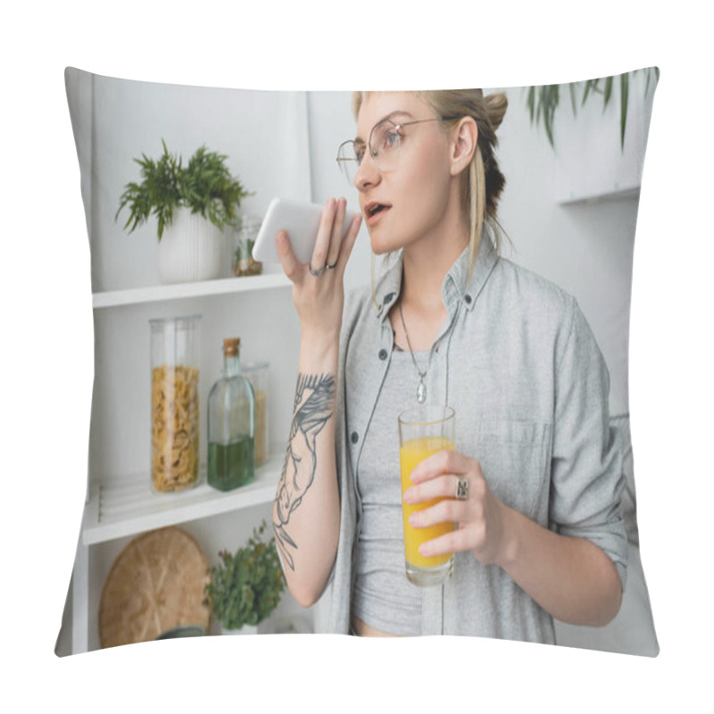 Personality  Tattooed Young Woman With Bangs And Eyeglasses Holding Glass Of Orange Juice And Recording Voice Message On Smartphone, Standing Near Blurred Green Plants And Rack In Modern White Kitchen   Pillow Covers