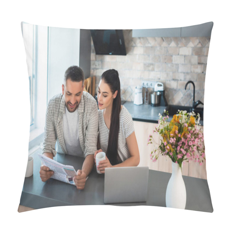 Personality  Portrait Of Smiling Married Couple Reading Newspaper Together At Counter With Laptop In Kitchen Pillow Covers