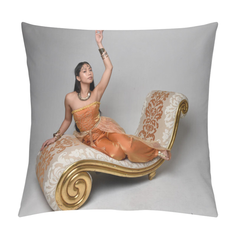 Personality  Full Length Portrait Of Pretty Young Asian Woman Wearing Golden Arabian Robes Like A Genie, Seated Pose On Lounge, Isolated On Studio Background. Pillow Covers