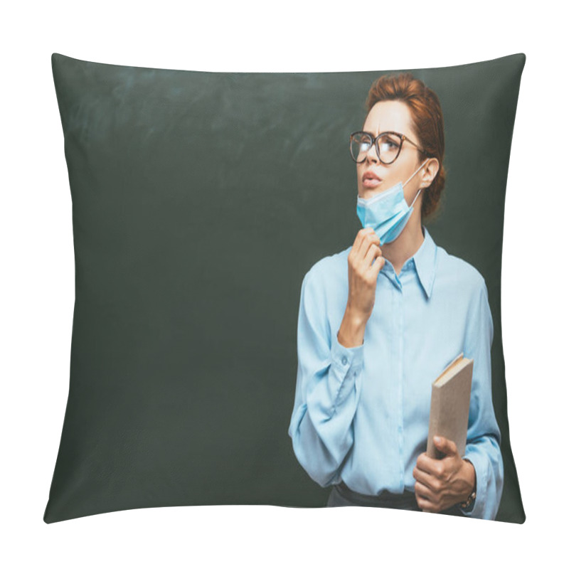 Personality  Teacher With Book Touching Medical Mask While Standing Near Chalkboard And Looking Away  Pillow Covers