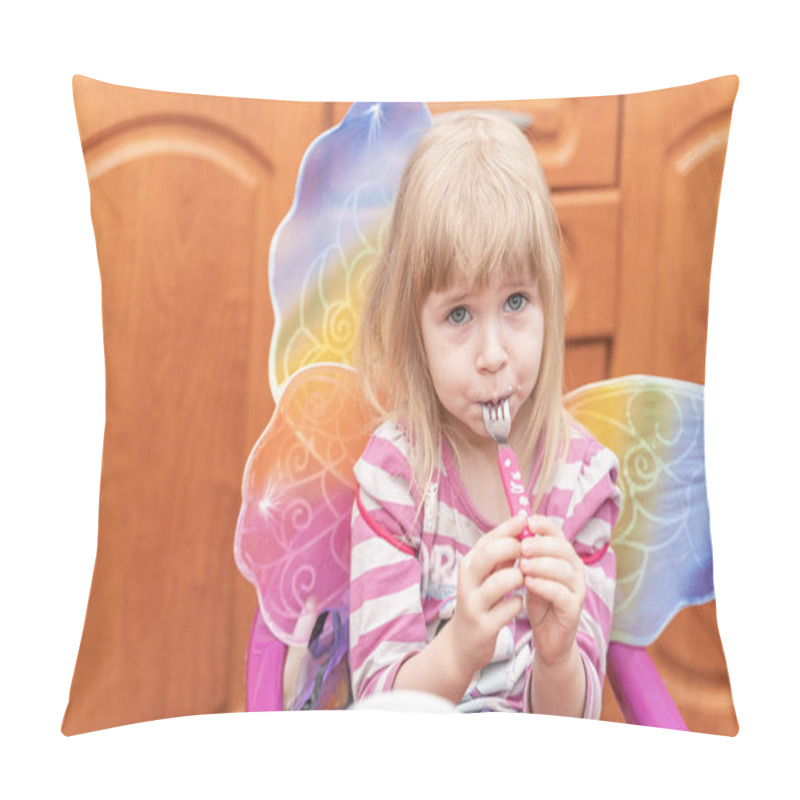 Personality  3 Years Old Girl With Blonde Hair Sitting In The Kitchen At Home And Eating. She Doesn`t Really Want To Eat And Taking Time By Holding Empty Fork In The Mouth. Candid Color Image. Pillow Covers