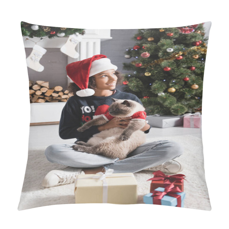 Personality  Happy African American Girl In Santa Hat Looking Away While Sitting Near Christmas Tree And Holding Fluffy Cat Pillow Covers