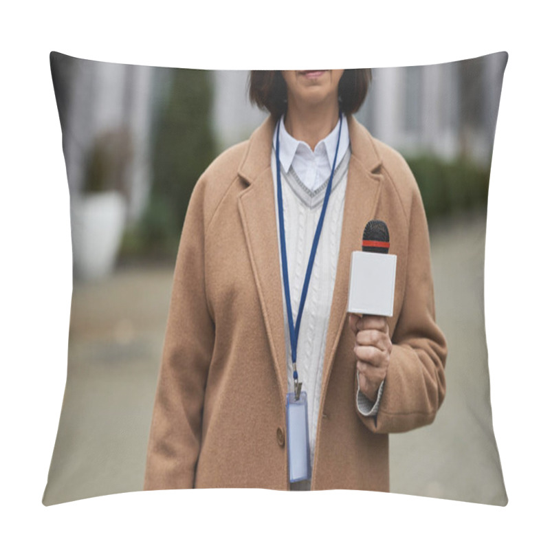 Personality  A Journalist In A Beige Coat Holds A Microphone, Ready To Share The Latest News In A Busy City Environment. Pillow Covers