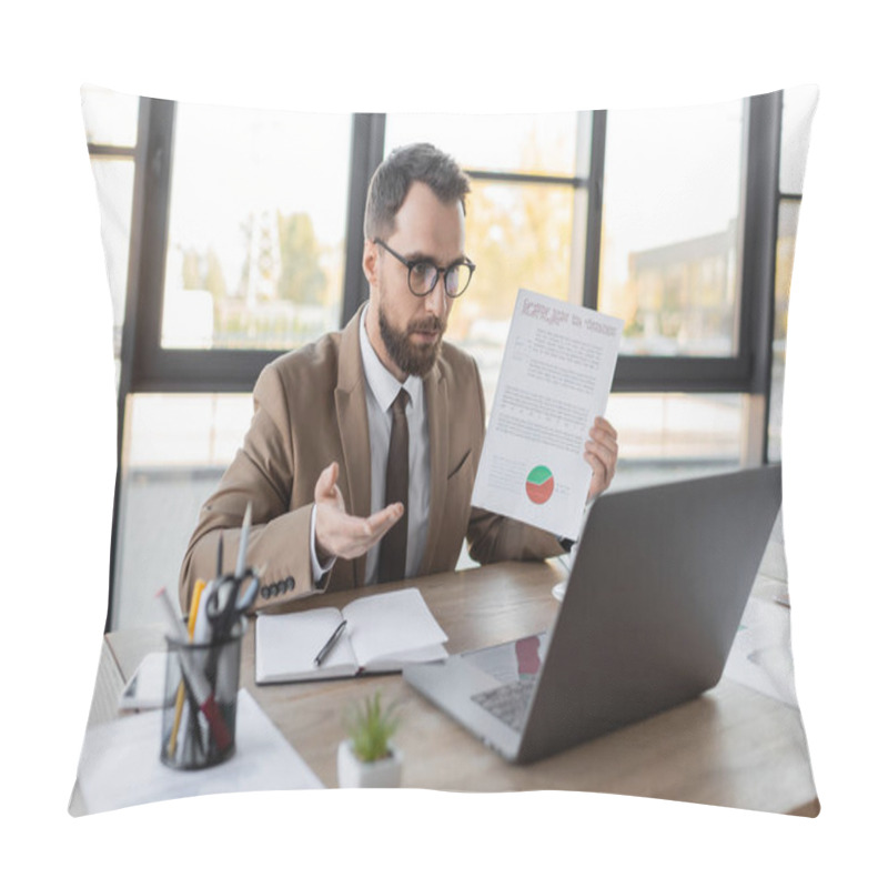 Personality  Bearded Businessman In Eyeglasses, Tie And Beige Blazer Showing Document With Market Research And Pointing With Hand During Video Conference On Laptop Near Notebook, Smartphone And Office Stationery Pillow Covers