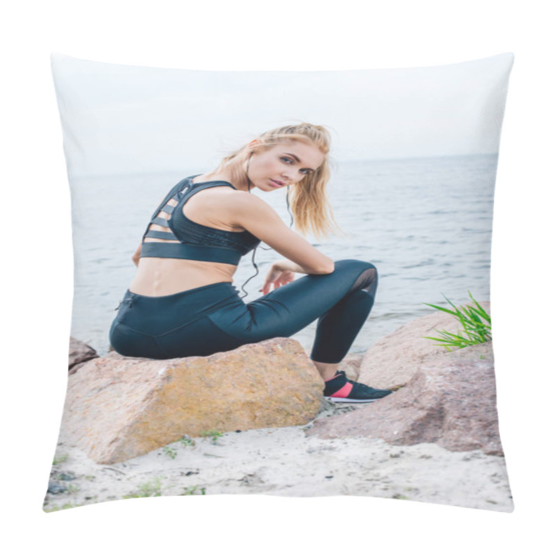 Personality  Attractive Blonde Woman In Sportswear Looking At Camera While Sitting On Stone And Listening Music Near Sea  Pillow Covers