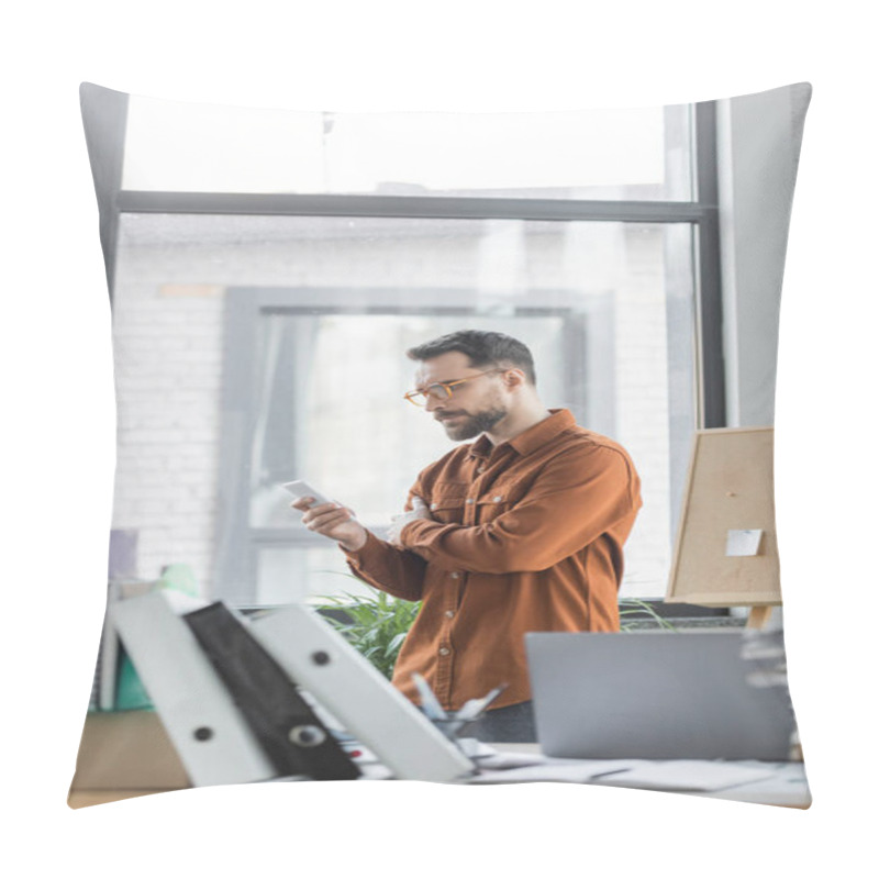 Personality  Serious Bearded Entrepreneur In Stylish Shirt And Eyeglasses Looking At Smartphone Next To Work Desk With Laptop, Plenty Of Folders And Notebooks On Blurred Foreground Pillow Covers