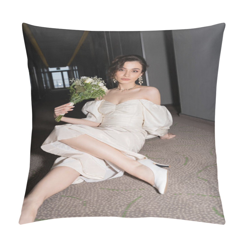 Personality  Young And Brunette Bride In White Wedding Dress Looking At Camera While Holding Bridal Bouquet With Flowers And Sitting On Floor Of Corridor In Modern Hotel  Pillow Covers