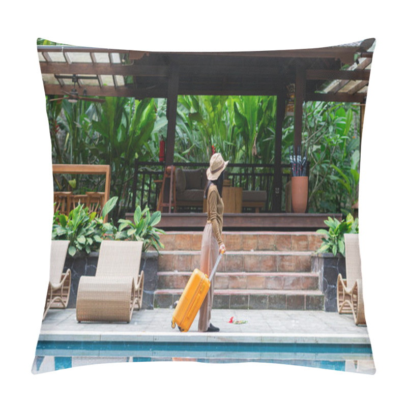 Personality  A Woman Walking By A Poolside With An Orange Suitcase, Wearing A Hat And Stylish Outfit. The Background Features Lush Greenery And A Wooden Structure, Creating A Tropical Vacation Vibe. Pillow Covers